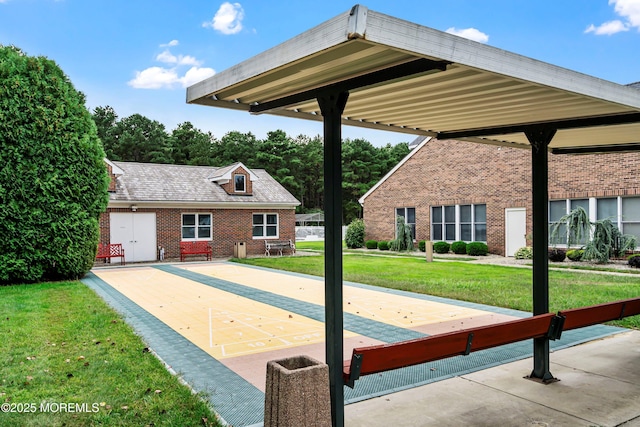 view of community featuring a lawn and shuffleboard