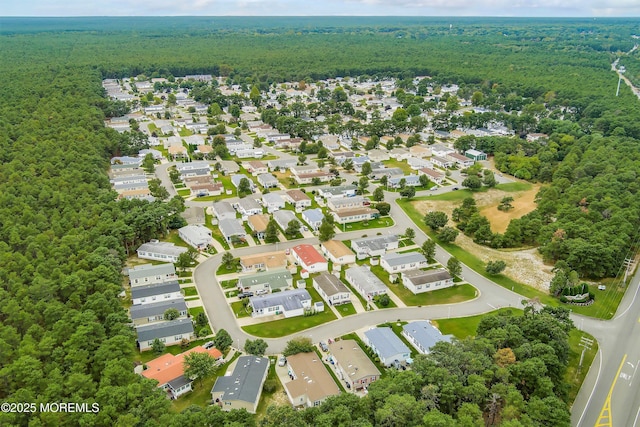 drone / aerial view featuring a residential view and a wooded view