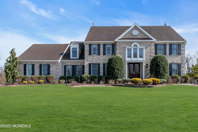 colonial inspired home featuring a front lawn, french doors, and brick siding