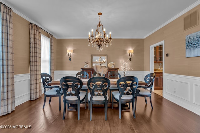 dining room with visible vents, wood finished floors, an inviting chandelier, and a wainscoted wall