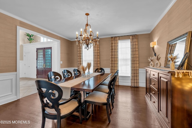 dining room featuring a notable chandelier, wainscoting, dark wood-type flooring, and ornamental molding