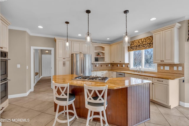 kitchen featuring light stone countertops, cream cabinetry, appliances with stainless steel finishes, crown molding, and backsplash