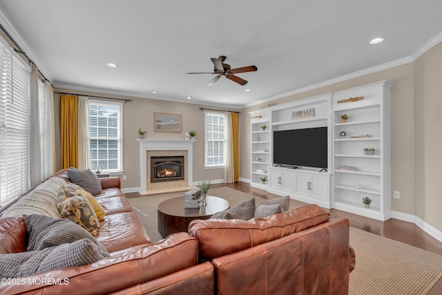 living room with plenty of natural light, crown molding, ceiling fan, and wood finished floors