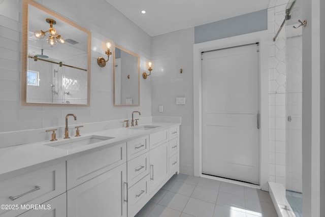 full bathroom featuring a tile shower, tile patterned flooring, and a sink