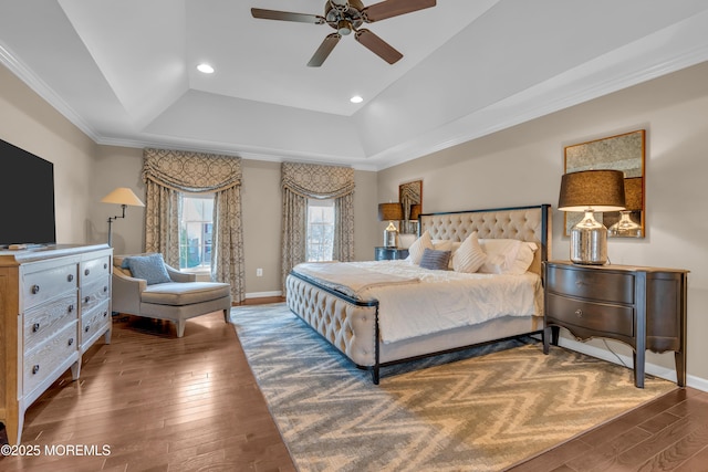 bedroom with a tray ceiling, baseboards, and hardwood / wood-style flooring