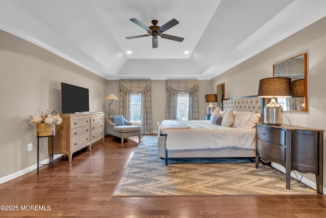 bedroom with ornamental molding, a tray ceiling, wood finished floors, recessed lighting, and baseboards