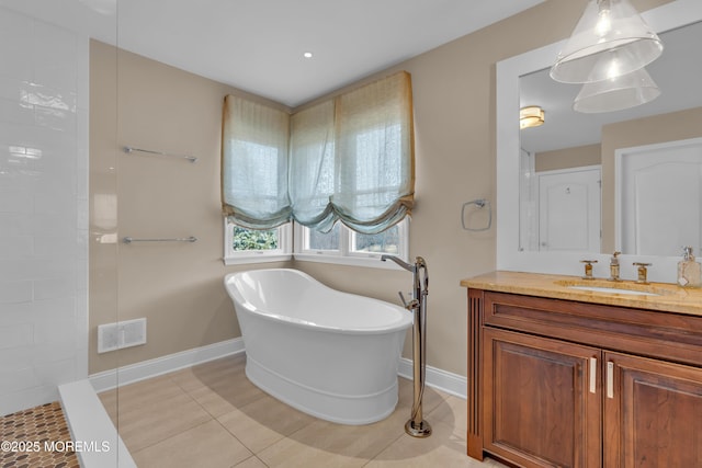 bathroom with visible vents, tile patterned flooring, baseboards, a freestanding bath, and vanity