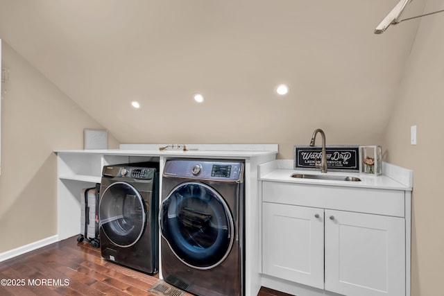 clothes washing area with washer and dryer, a sink, dark wood finished floors, baseboards, and laundry area