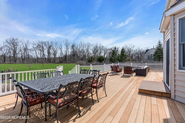 wooden terrace featuring outdoor dining space, outdoor lounge area, and a yard