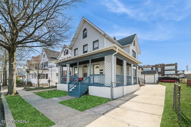 view of front of house featuring a porch, an outdoor structure, a garage, a front lawn, and concrete driveway