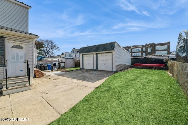 exterior space featuring an outbuilding, a detached garage, entry steps, and a fenced backyard