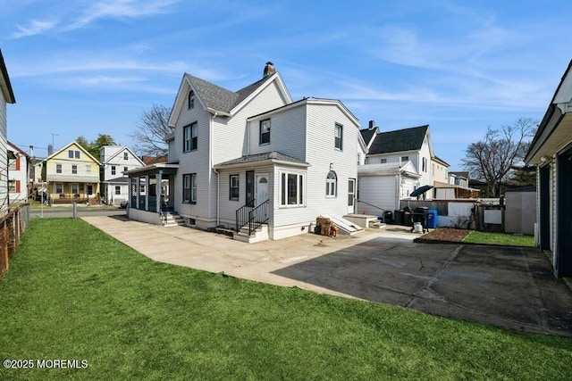 rear view of property with fence, entry steps, a residential view, a patio area, and a lawn