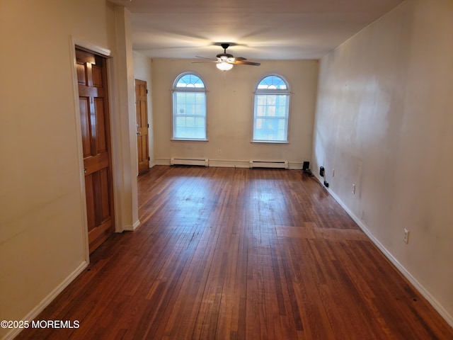 empty room featuring a ceiling fan, baseboards, baseboard heating, and dark wood finished floors