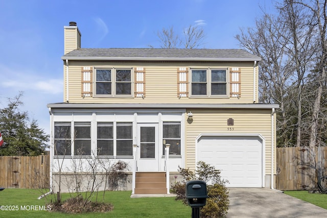 view of front facade featuring a front yard, concrete driveway, a chimney, and fence