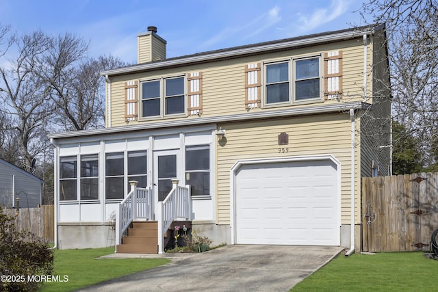 traditional-style home with a sunroom, an attached garage, a chimney, and fence