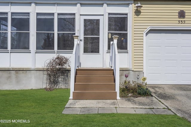 doorway to property with a garage and a lawn