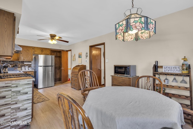 dining space with light wood-type flooring and a ceiling fan