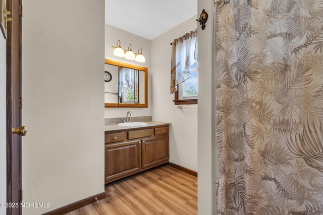 bathroom featuring vanity, wood finished floors, and baseboards