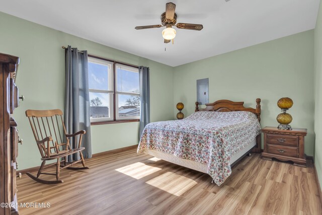 bedroom featuring ceiling fan, baseboards, and light wood-style floors