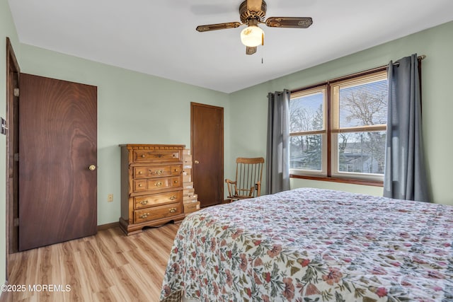 bedroom featuring baseboards, light wood finished floors, and ceiling fan