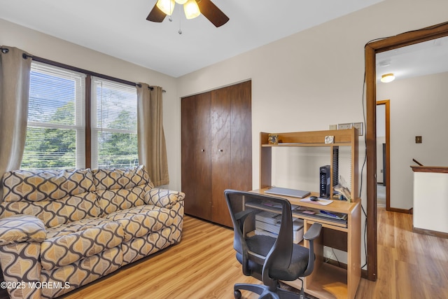 office space with light wood-style flooring, baseboards, and ceiling fan