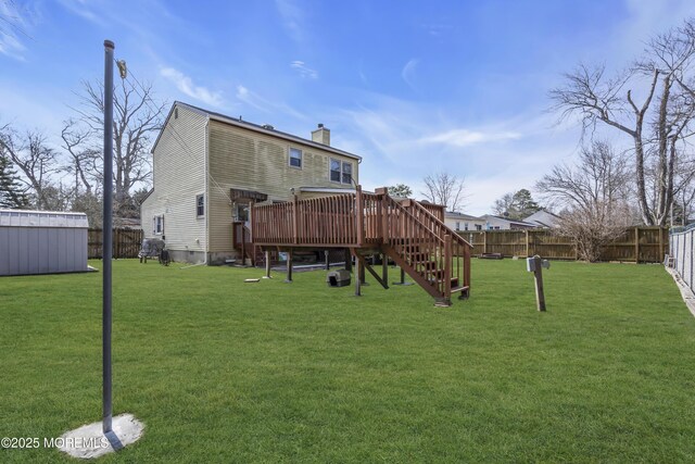 back of house with a fenced backyard, a yard, a chimney, and a deck