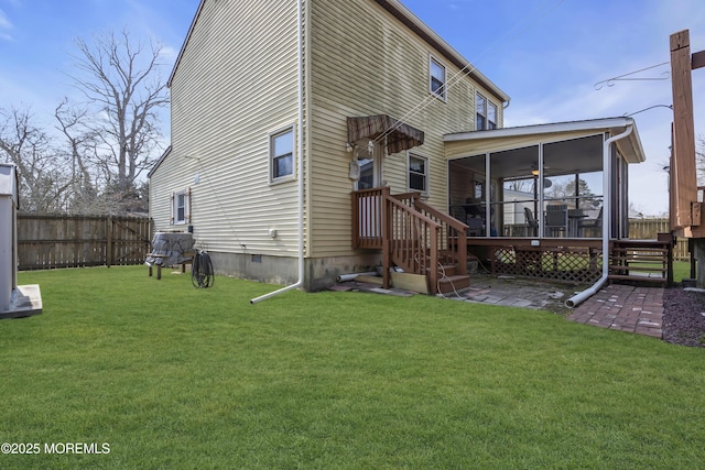 rear view of property with fence, a yard, a sunroom, crawl space, and a patio area