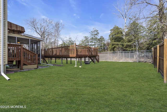 view of yard with stairway, a fenced backyard, a sunroom, and a wooden deck