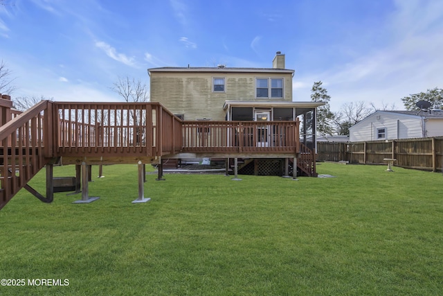 back of house with a deck, fence, a lawn, and a chimney