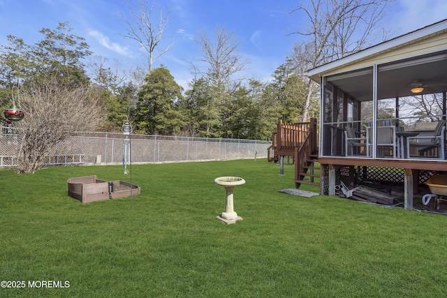 view of yard featuring a wooden deck, a sunroom, stairs, and fence