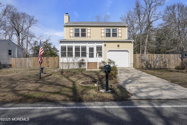 traditional-style house with a garage, a chimney, driveway, and fence