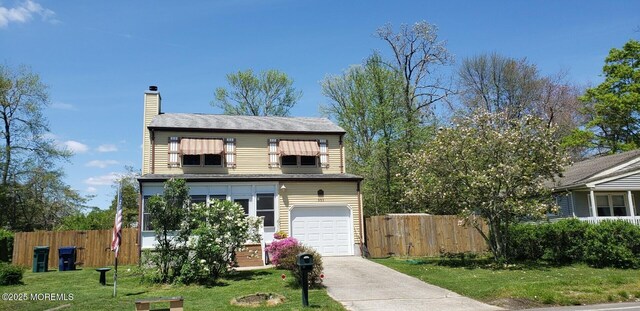 view of front of home featuring a front lawn, concrete driveway, fence, and a chimney