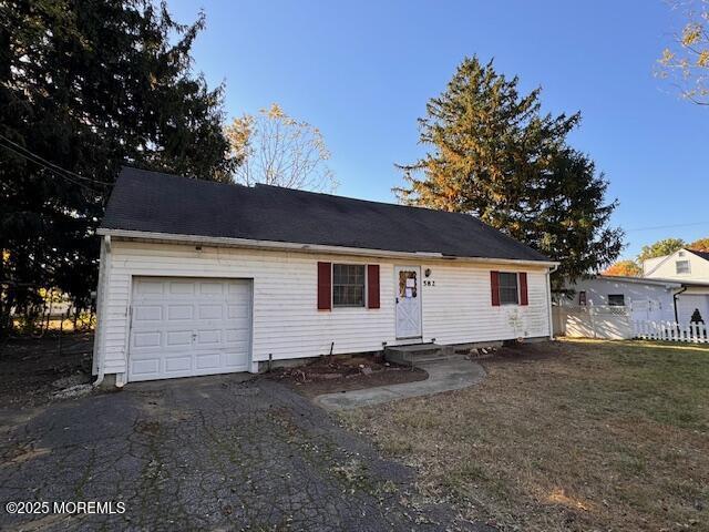 single story home featuring entry steps, an attached garage, and driveway