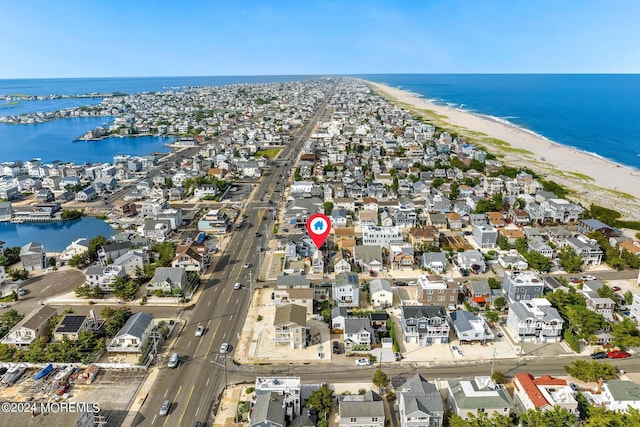 drone / aerial view featuring a residential view, a beach view, and a water view