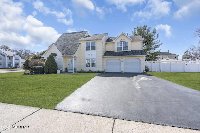 view of front facade with a shingled roof, fence, a front yard, a garage, and driveway