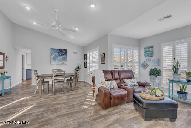 living area with visible vents, baseboards, light wood-type flooring, vaulted ceiling, and recessed lighting