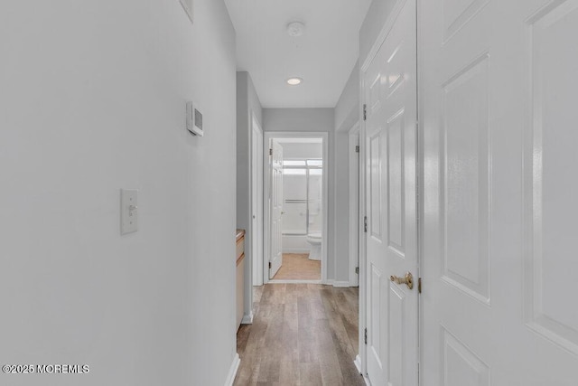 hall featuring wood finished floors and baseboards