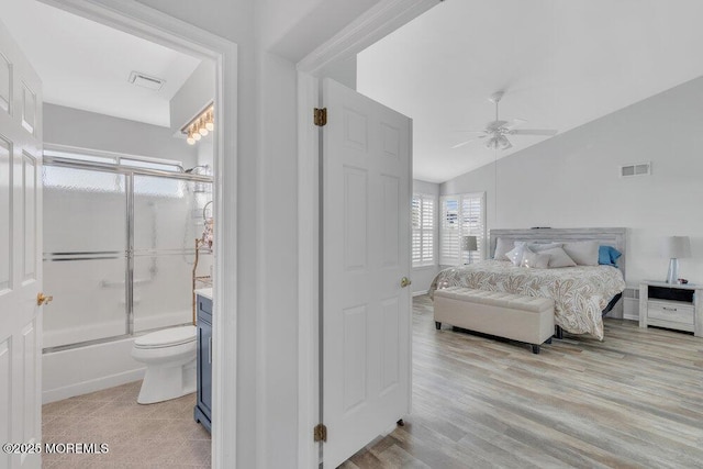 bedroom featuring ceiling fan, visible vents, wood finished floors, and vaulted ceiling