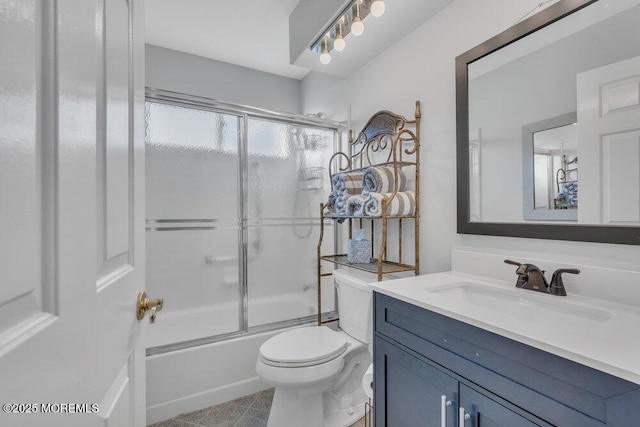 bathroom featuring enclosed tub / shower combo, toilet, and vanity