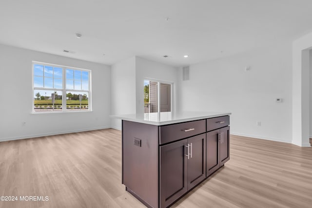 kitchen featuring open floor plan, light wood-style flooring, baseboards, and visible vents