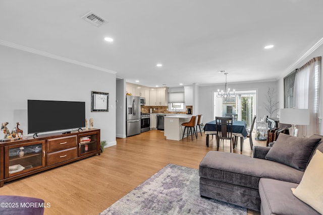 living area featuring visible vents, ornamental molding, recessed lighting, light wood-style floors, and a notable chandelier