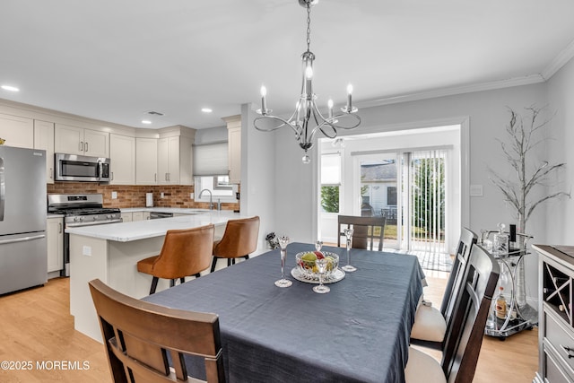 dining area featuring visible vents, recessed lighting, an inviting chandelier, crown molding, and light wood finished floors