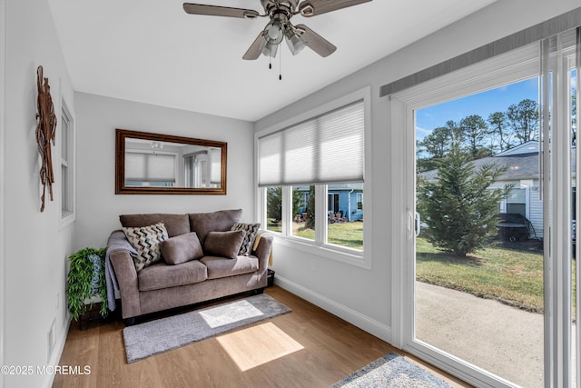 living area with ceiling fan, baseboards, and wood finished floors