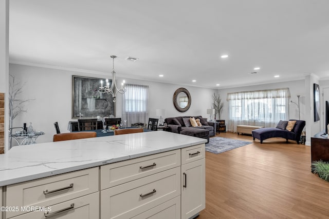 kitchen featuring visible vents, open floor plan, and ornamental molding