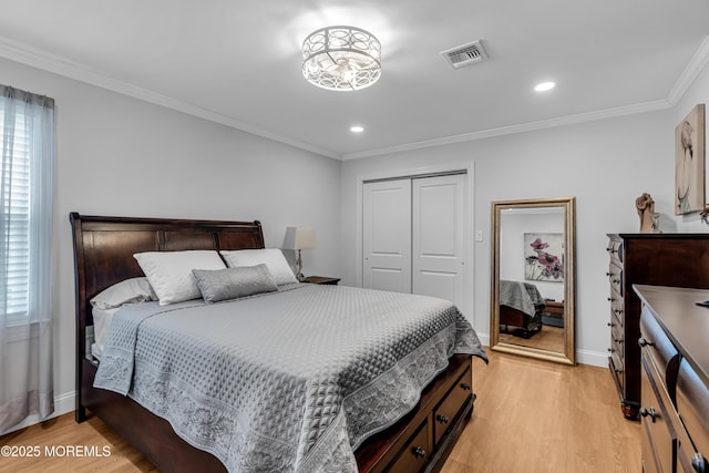 bedroom with visible vents, crown molding, baseboards, light wood-style flooring, and a closet