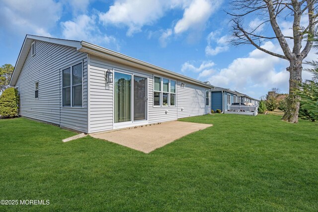 back of house with a deck, a patio, and a yard