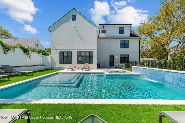 back of property featuring a patio, a yard, a fenced backyard, a pool with connected hot tub, and stucco siding