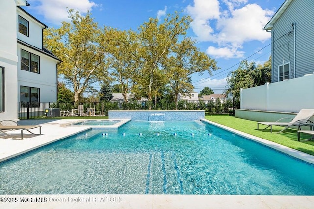 view of pool featuring a patio, a pool with connected hot tub, and fence