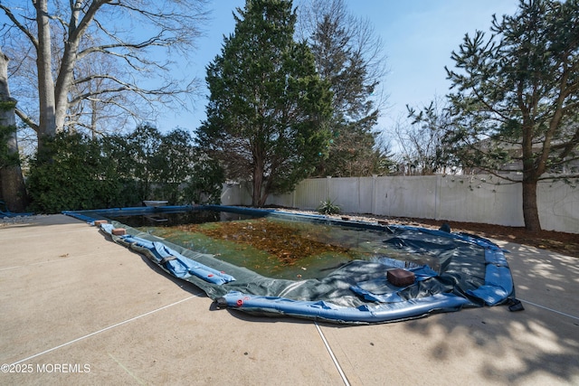 view of pool with a diving board, a fenced in pool, a fenced backyard, and a patio area