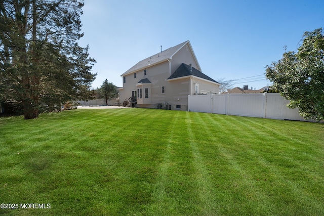 rear view of house featuring a yard, a patio, and a fenced backyard